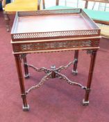 A mahogany reproduction occasional table, with pierced fretwork gallery and cluster column legs,