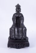 An Asian bronze, seated figure, on a carved wood base, height 41cm.