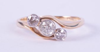 An 18ct yellow gold three stone twist style ring set with round brilliant cut diamonds, total