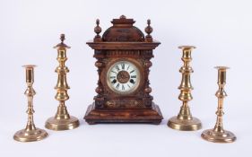 A Victorian carved walnut cased mantle clock together with two pairs of brass candlesticks.