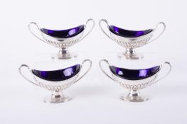 A set of four Victorian silver table salts with blue glass liners, Edward Hutton, London, 1890-91,