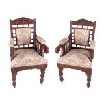 A pair 19th century Anglo Indian style ornately carved hardwood chairs with dragon scroll arms, over