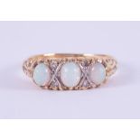 An 18ct yellow gold scroll design ring set with three oval cabochon cut opals interspaced by four