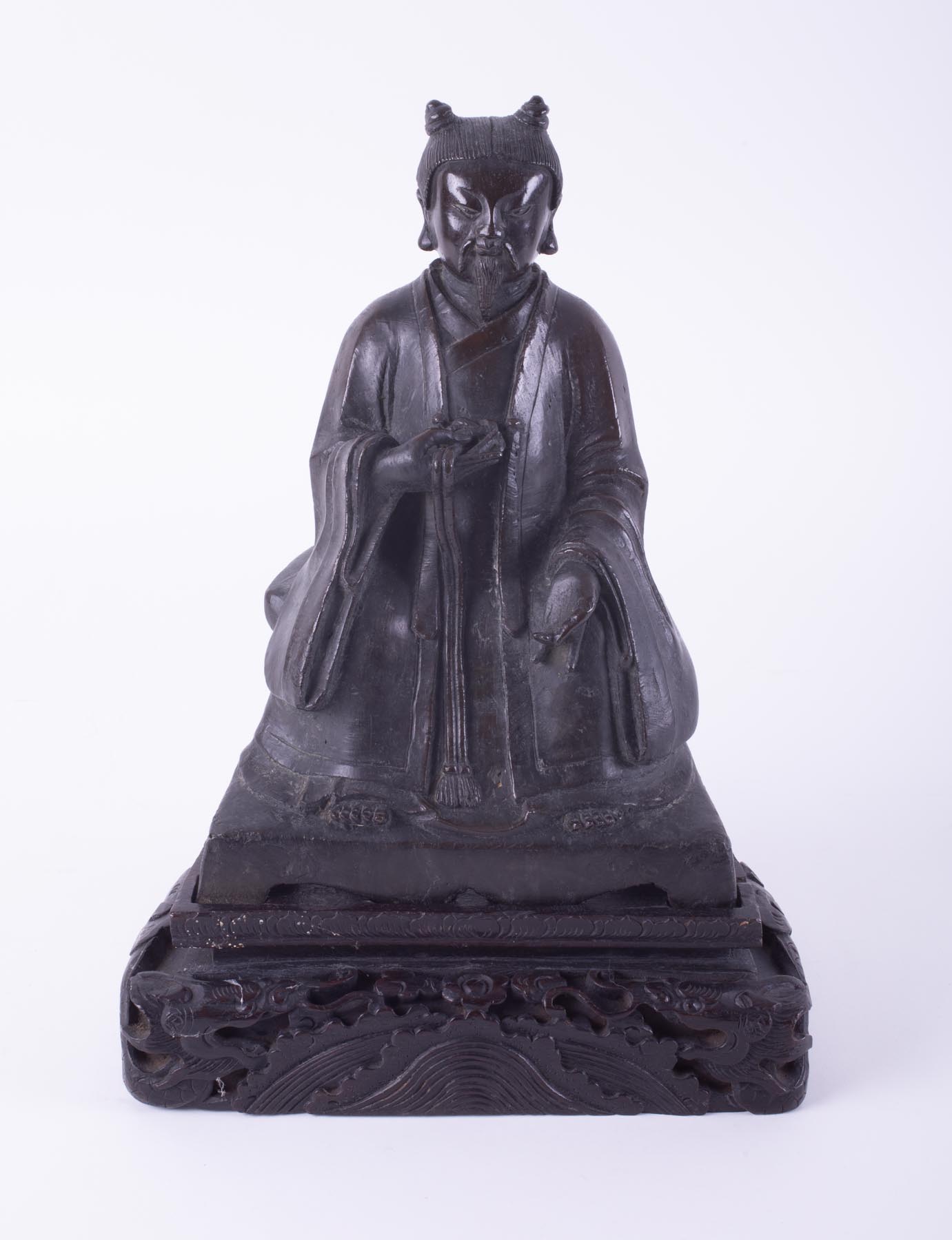 An Asian bronze, seated figure, on a carved wood base, height 36cm.