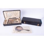 A three piece dressing table set comprising silver back hand mirror a pair of silver back brushes,