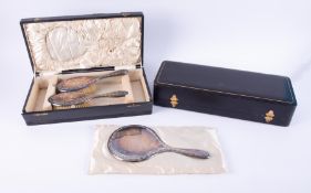 A three piece dressing table set comprising silver back hand mirror a pair of silver back brushes,