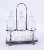 A silver plated three bottle tantalus with a swing top carrying handle.