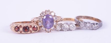 Four rings to include a 9ct yellow gold ring set garnets, 2.63gm, size L, a 9ct yellow gold & silver