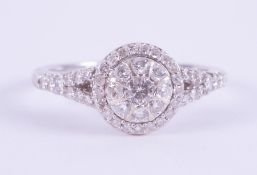 A 9ct white gold halo design ring set with 0.50 carats total weight of round brilliant cut diamonds,