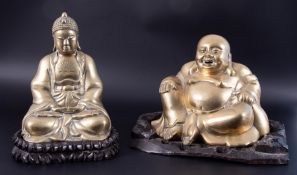 Two brass buddha's on carved wooden stands, tallest including base 29cm (2).