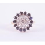 An 18ct yellow & white gold cluster ring set with small round brilliant cut diamonds surrounded by a