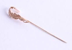 A 14k yellow gold stick pin decorated with fresh water pearl, approx. 2.71g.