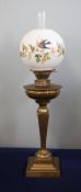 A Victorian oil lamp with white shade decorated with flowers, height excluding chimney 63cm.