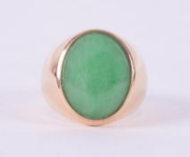 An 18ct yellow gold signet ring set with an oval cabochon cut jade, measuring approx. 16mm x 12.5mm,