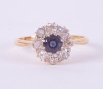 An 18ct yellow gold & platinum daisy ring set with a central round cut sapphire, approx. 0.35