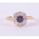 An 18ct yellow gold & platinum daisy ring set with a central round cut sapphire, approx. 0.35