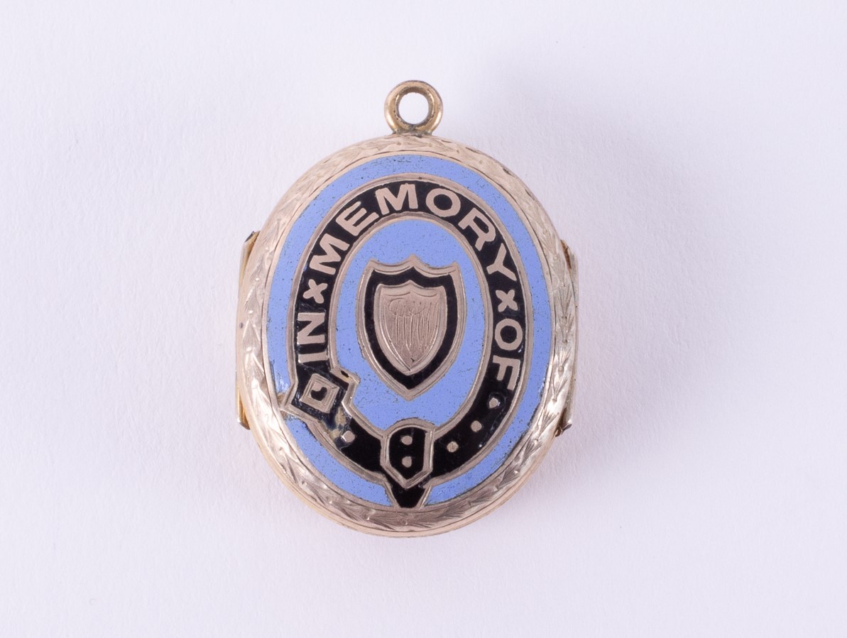A double sided memorial locket with engraved floral pattern to one side and blue & black