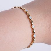 An 18ct yellow gold bracelet set with alternating gold oval links and round links set with