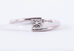 An 18ct white gold crossover design ring set with a princess cut diamond, approx. 0.30 carats,