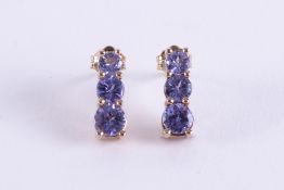 A pair of 9ct yellow gold stud earrings set with three graduated sized round cut tanzanite's, length