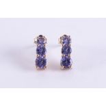 A pair of 9ct yellow gold stud earrings set with three graduated sized round cut tanzanite's, length