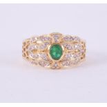 An 18ct yellow & white gold ring stamped 18k 750 set centrally with an oval cut emerald measuring