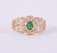 An 18ct yellow & white gold ring stamped 18k 750 set centrally with an oval cut emerald measuring