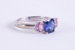 A 14k white gold three stone ring set with a central square fancy cut blue sapphire, approx. 1.15