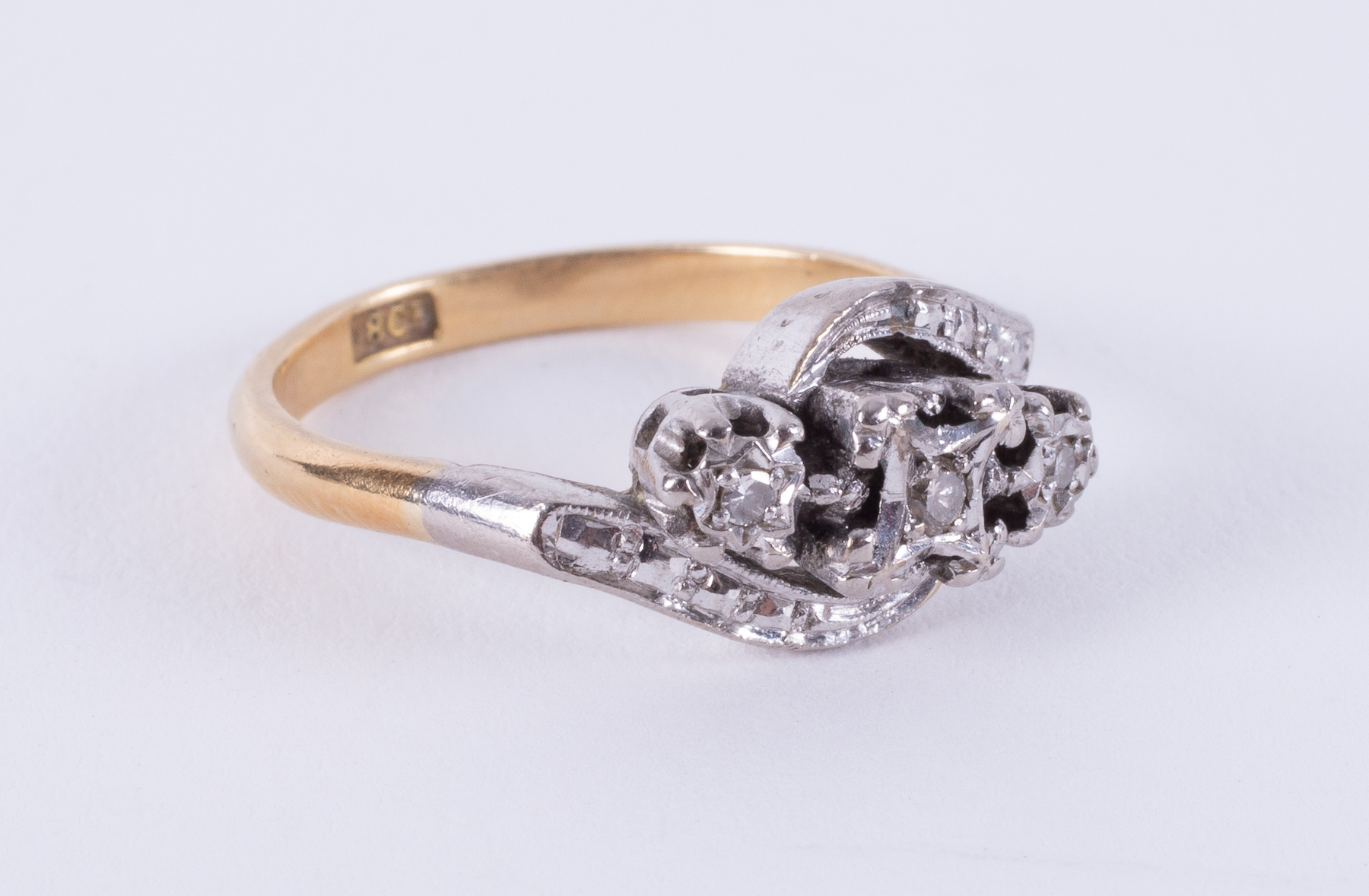 An 18ct yellow gold & platinum twist design ring set with three small round cut diamonds