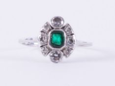 A platinum ring (not hallmarked or tested) set with a central emerald cut emerald, approx. 0.32