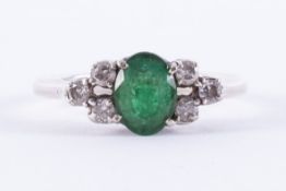 A white gold ring (no hallmarks & not tested) set with a central oval cut emerald, approx.0.94