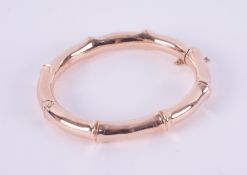 An antique 9ct rose gold bamboo design hinged bangle, London hallmark 1916-17, with safety chain,