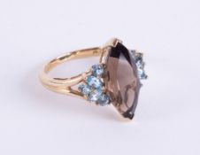A 9ct yellow gold ring set with a central marquise shaped smokey quartz with a mixture of marquise