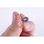 A 9ct yellow gold ring set with a central marquise cut tanzanite and tiny round cut diamonds set