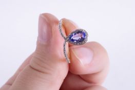 A 9ct yellow gold ring set with a central marquise cut tanzanite and tiny round cut diamonds set