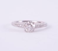 A platinum ring set with a central round brilliant cut diamond, 0.74 carats, colour G & SI1 clarity,