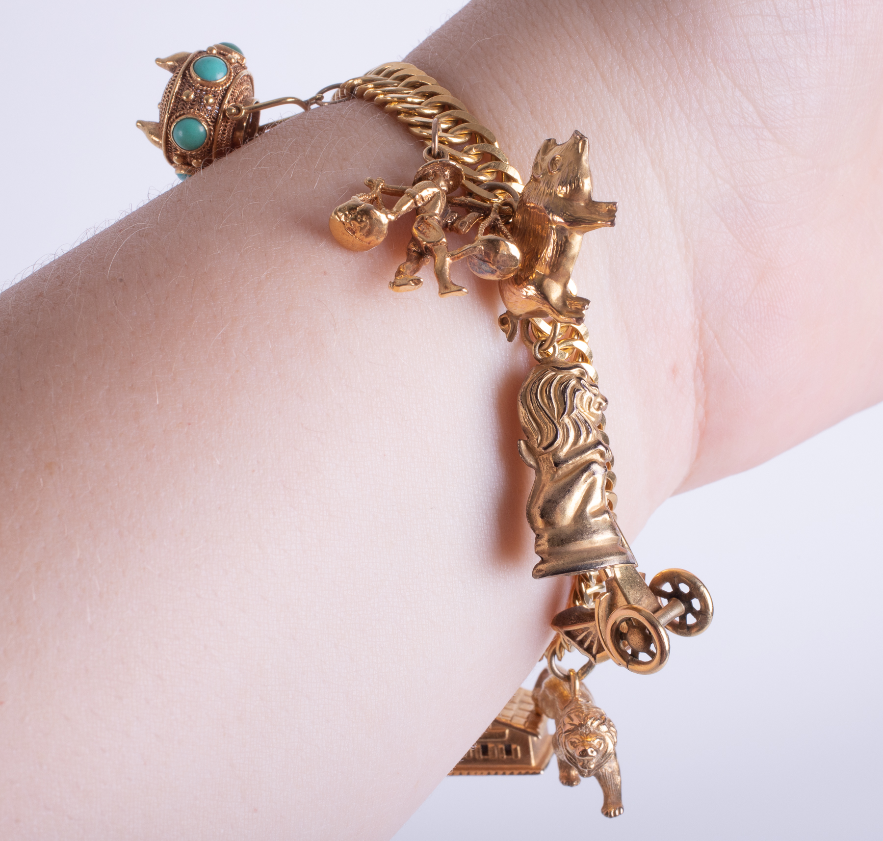 A high carat charm bracelet (indistinct marking but probably 14ct plus) with ten gold charms, five