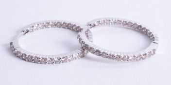 A pair of 18ct white gold hoop earrings set with round brilliant cut diamonds, total diamond