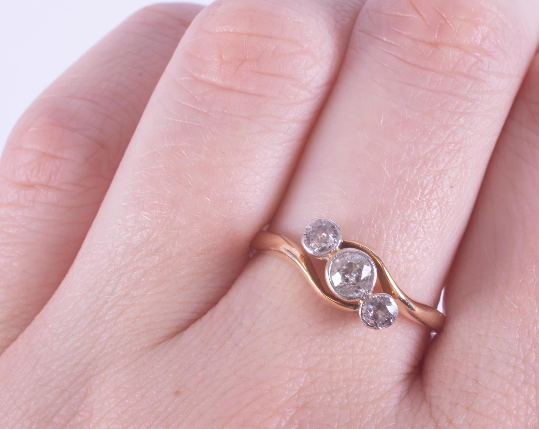 An 18ct yellow gold three stone twist style ring set with round brilliant cut diamonds, total - Image 2 of 2