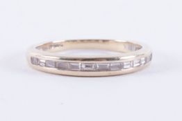 An 18ct white gold half eternity style ring set with baguette cut diamonds (please note one of the