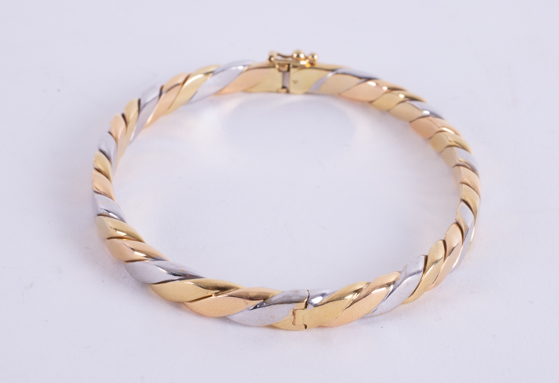 An 18ct yellow, white & rose gold twist design hinged bangle with push in clasp & figure of eight - Image 2 of 2