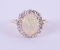 An 18ct white and yellow gold oval opal and diamond cluster ring, size P.