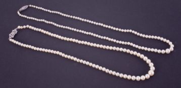 Two strings of pearls to include a string of graduated cream cultured pearls ranging from 3.5mm to