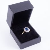 An impressive 18ct yellow & white gold cluster ring set with a central oval cut sapphire, approx.