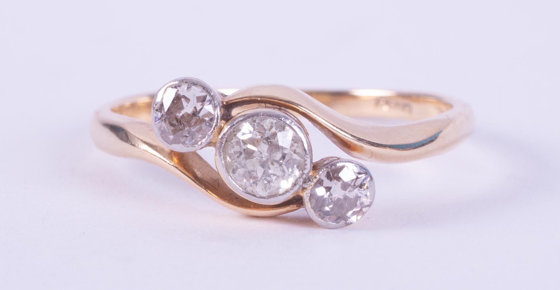 An 18ct yellow gold three stone twist style ring set with round brilliant cut diamonds, total