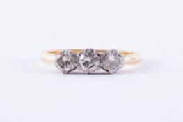 An 18ct yellow & white gold three stone ring set with three older round cut diamonds, total