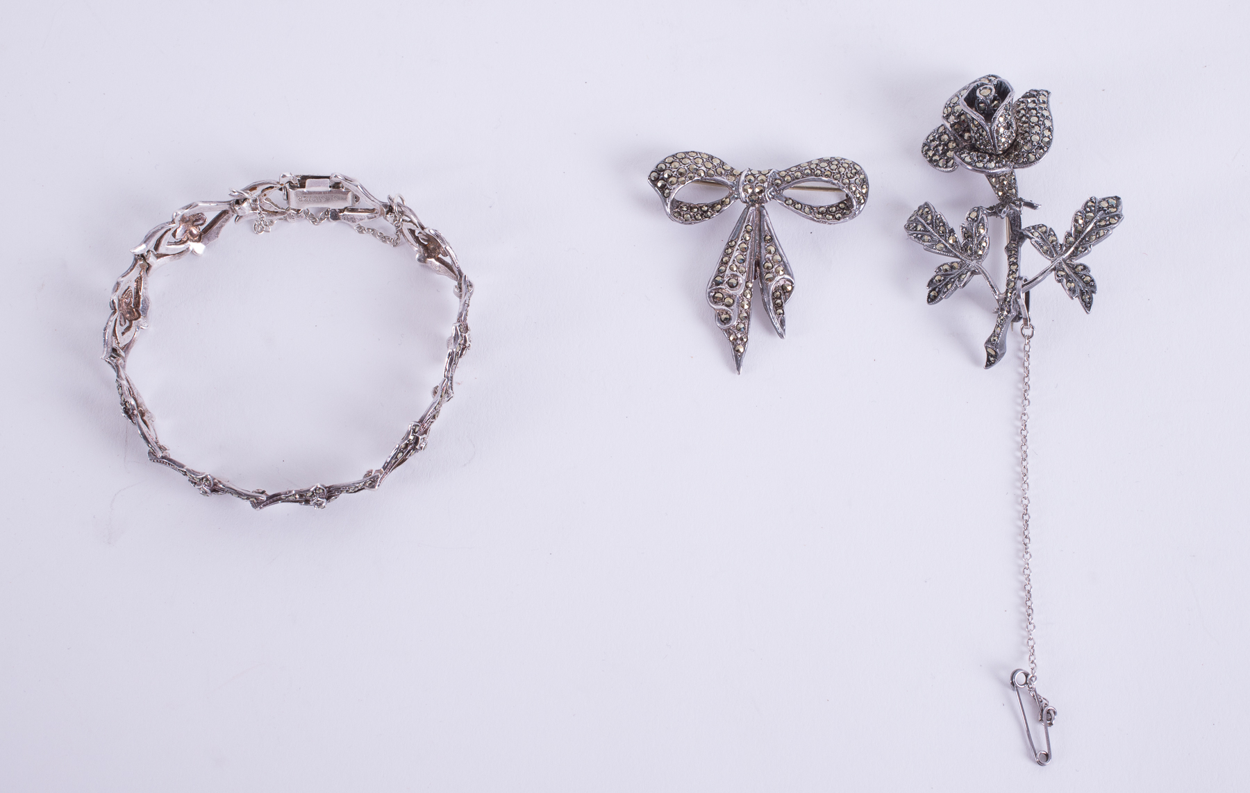 A mixed lot of three jewellery items to include an ornate silver bracelet set with marcasite,