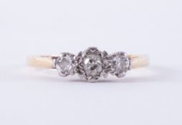 An 18ct yellow gold & platinum three stone ring set with three older round cut diamonds, total