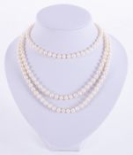 A three row strand of white freshwater 'rice krispy' pearls strung to a silver gilt clasp, length