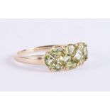 A 9ct yellow gold ring set with a mix of square cut & triangular cut peridot, 2.67gm, size U.